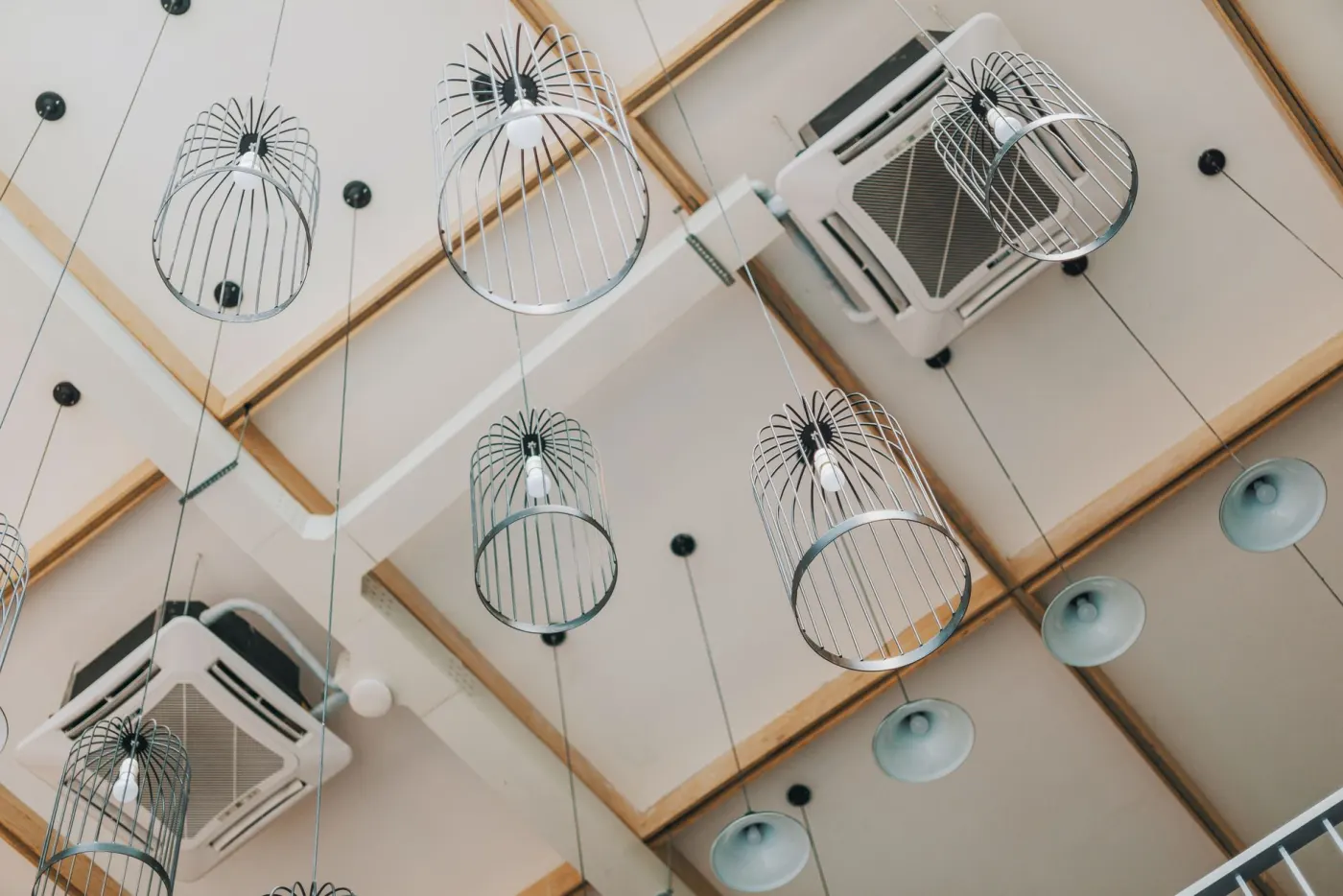 Deux cassettes de climatisation encastrées dans un plafond suspendu, soufflage sur quatre faces